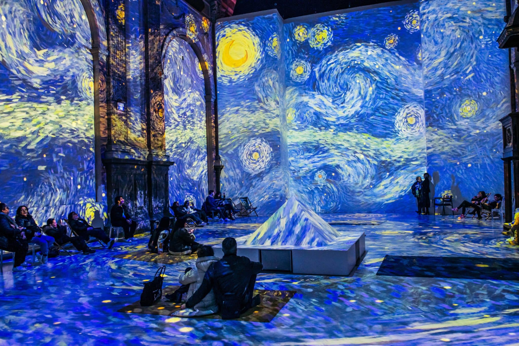 Van Gogh Immersive — Starry Night floor-to-ceiling projection with visitors lying down